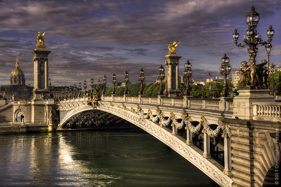 The pont Alexandre III bridge in early morning light with reflections on the River Seine and gold details blazing brightly