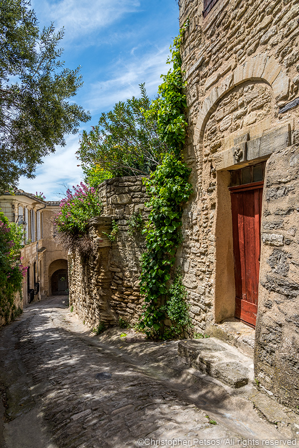 Small village street with a red door in Gordes, a town in Provence