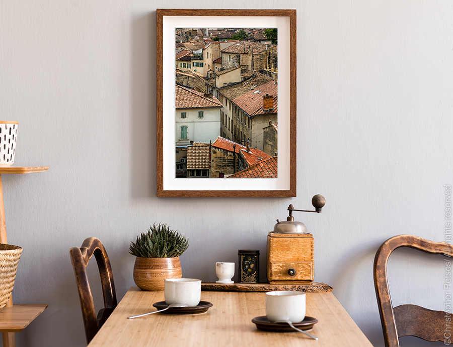 Avignon print by Christopher Petsos hanging above a cafe table