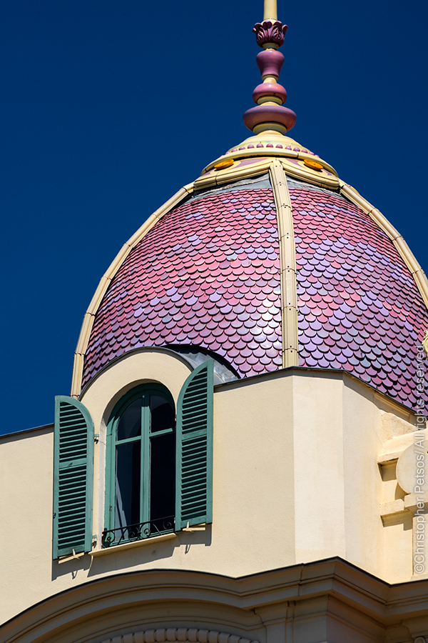architecture photo of pink and purple dome with yellow facade and teal shutters