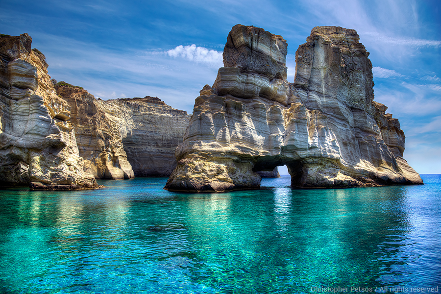rocks and stone arch with blue and turquoise water in MIlos