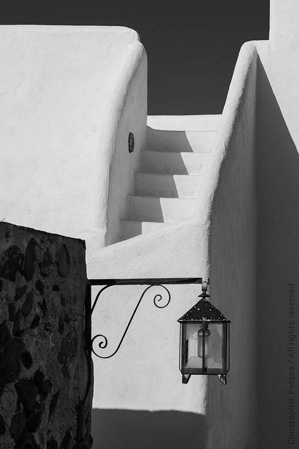 black and white cycladic architecture with steps, lantern, and dramatic shadows in Santorini