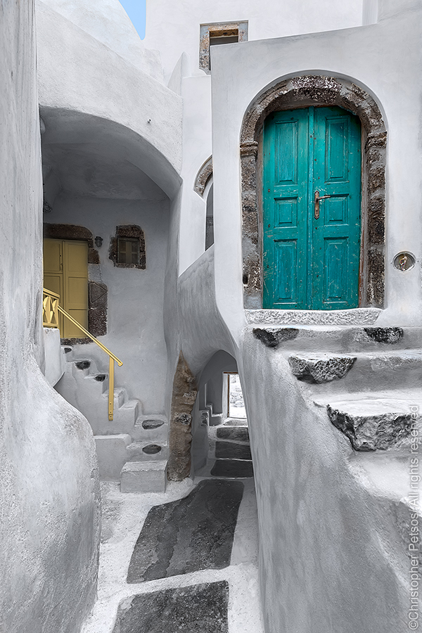 Two doors and whitewashed village architecture with steps and passages in Santorini, Greece