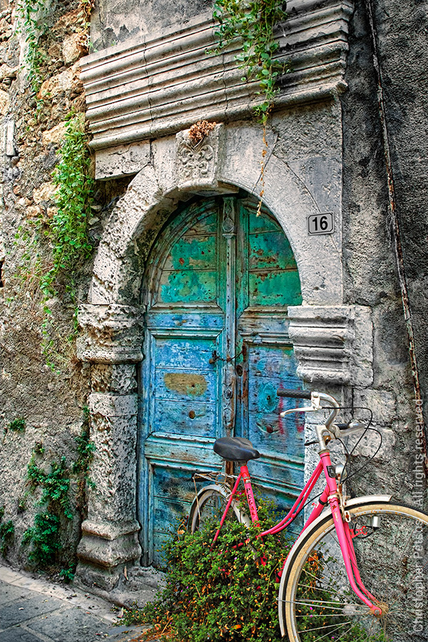 Turquoise and blue island door with a bicycle and plants