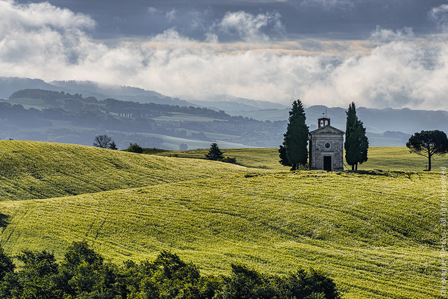Green hills and church with clouds in Tuscany, Italy