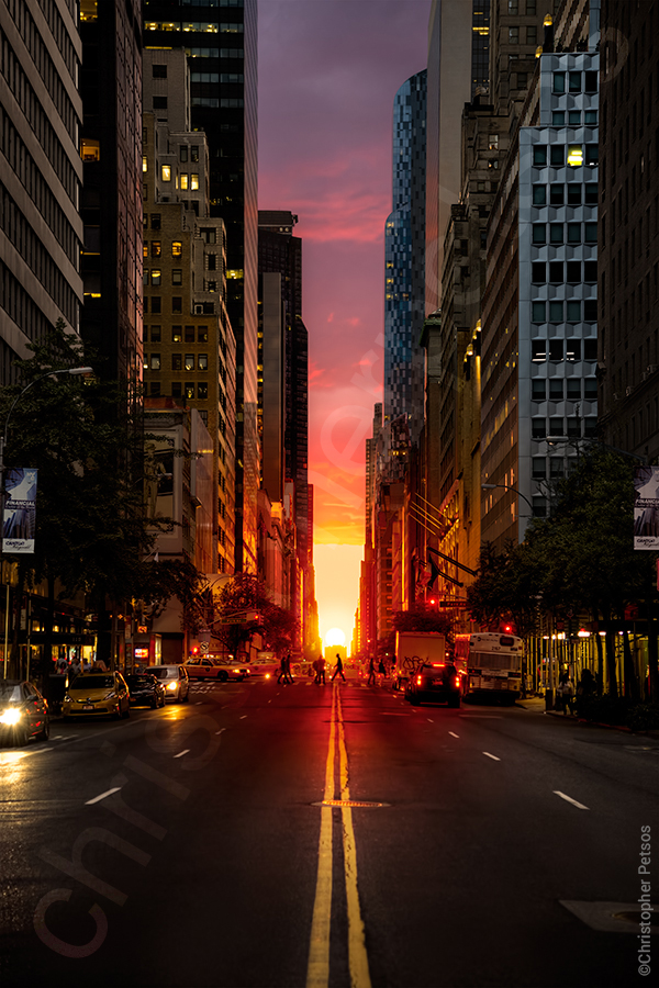 Manhattanhenge on 57th street with sun setting and skyscrapers by Christopher Petsos